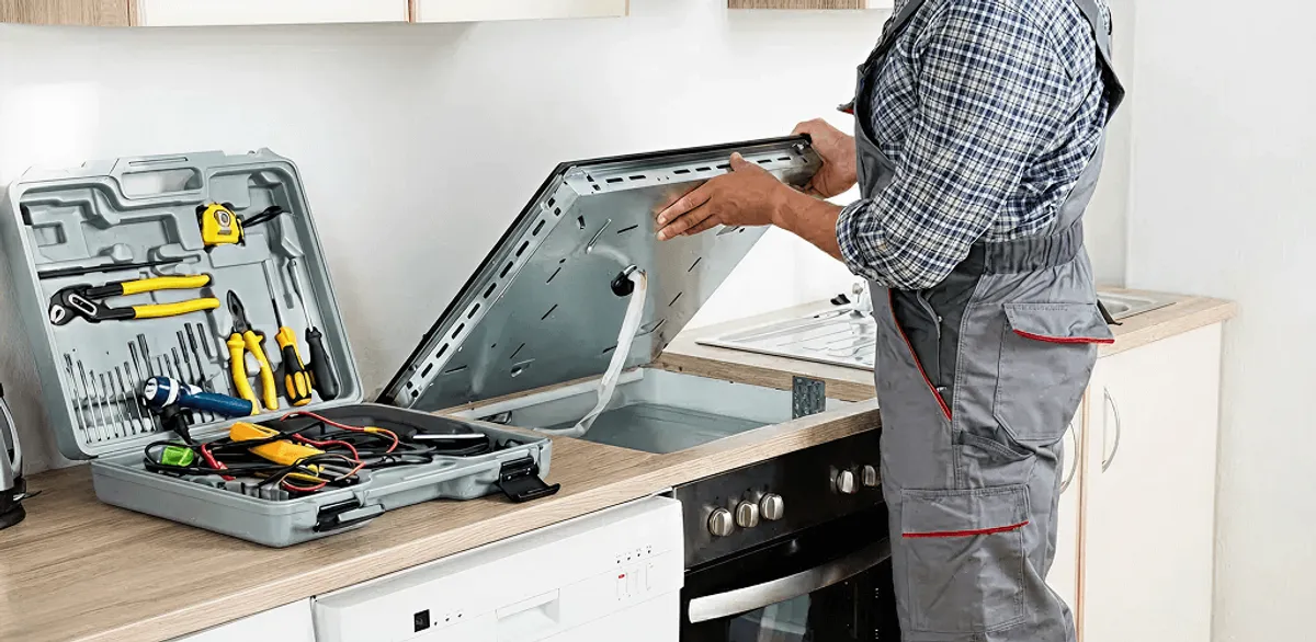 Handyman repairing a cooktop and checking wiring connections in Arvada, CO