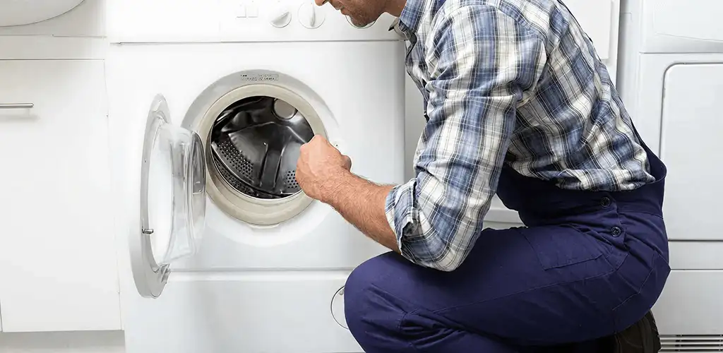 Handyman inspecting a dryer drum and internal parts for repair in Arvada, CO