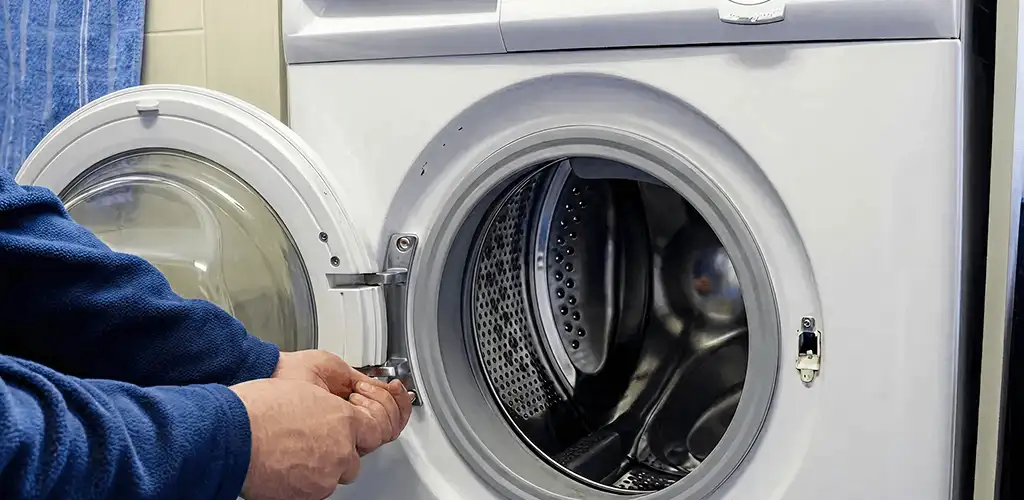 Washing machine repair handyman checking a front-load washer door and latch in Arvada, CO