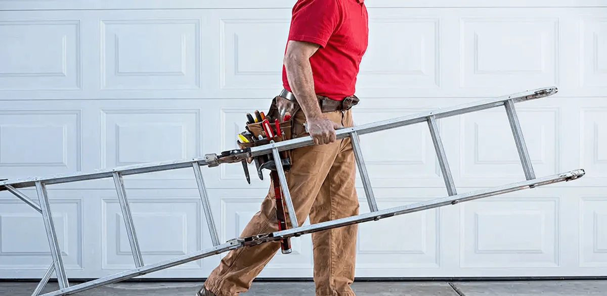 Garage door repair technician arriving with tools and ladder in Arvada, CO