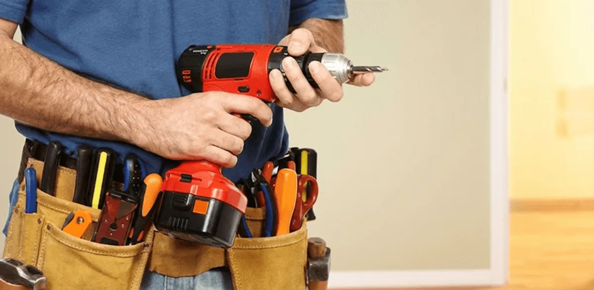 Handyman holding a power drill for home repairs and installations in Arvada, CO