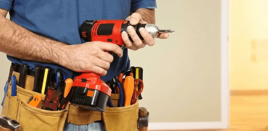 Handyman holding a power drill for home repairs and installations in Arvada, CO