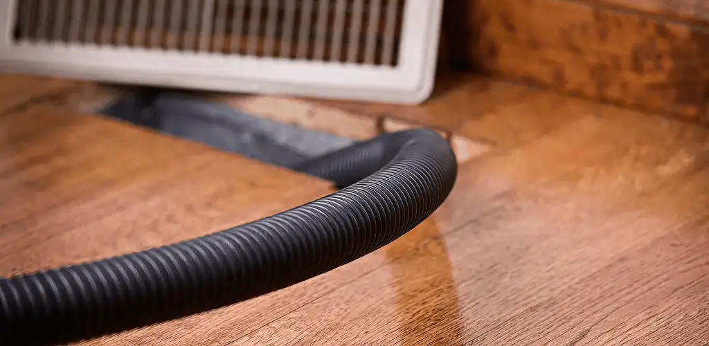Air duct cleaning hose inserted into a floor vent for ductwork cleaning in Arvada, CO