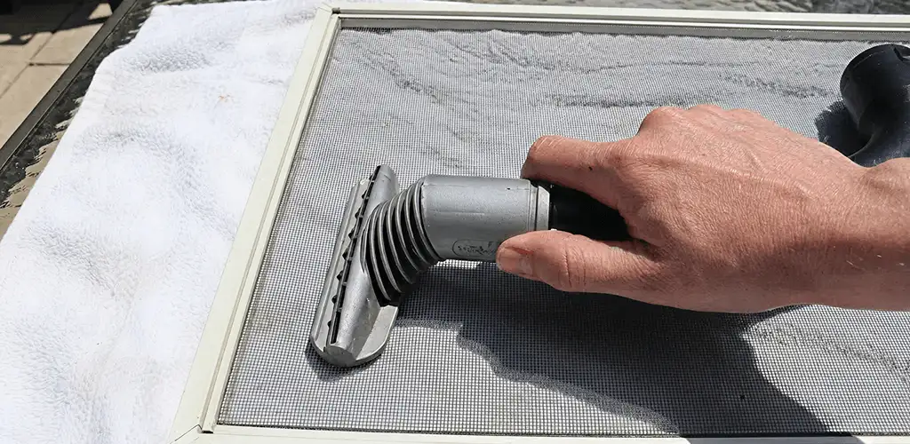 Window screen repair cleaning and fixing a damaged screen mesh in Arvada, CO